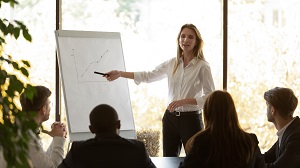 female pointing on flip chart presenting work results graph at conference office meeting | hoa committee guidelines
