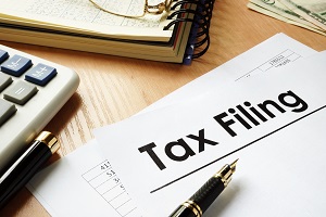 papers with title Tax filing on an office desk | do homeowners associations have to file tax returns