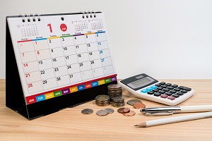 calendar, stack of coins, calculator and pen | hoa fees