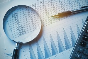 magnifying glass, pen and calculator over financial report | homeowners association accounting