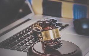 gavel on computer with legal books in background | do hoa fees go up