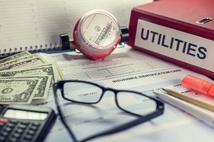 payment of utilities, receipt, bills, calculator and a folder with inscription "Utilities" | reducing HOA budget