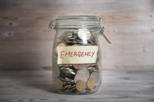 coins in glass money jar with emergency label | what is a reserve fund