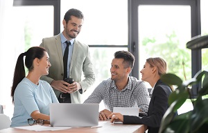 smiling employees having a chat in the office | financial manager for an HOA