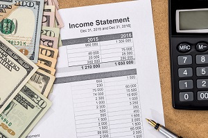 income statement document with pen, calculator and money | homeowners association income statement