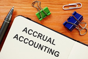 accrual accounting written on paper placed on wooden desk together with paper clips | modified accrual accounting for HOA