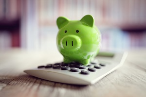 piggy bank over a calculator | HOA reserve study firm
