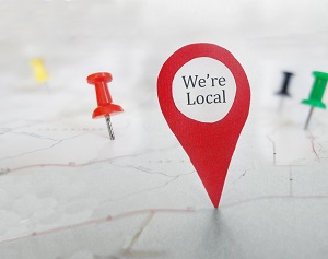 Red locator symbol with We're Local message, on a map with tacks | HOA financial system