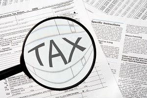 tax forms under a magnifying glass | financial tips for an HOA