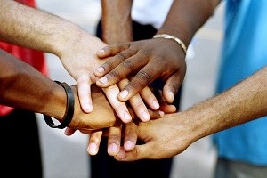 group of people piling hand together | rule compliance